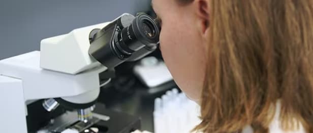 A researcher working with a microscope 